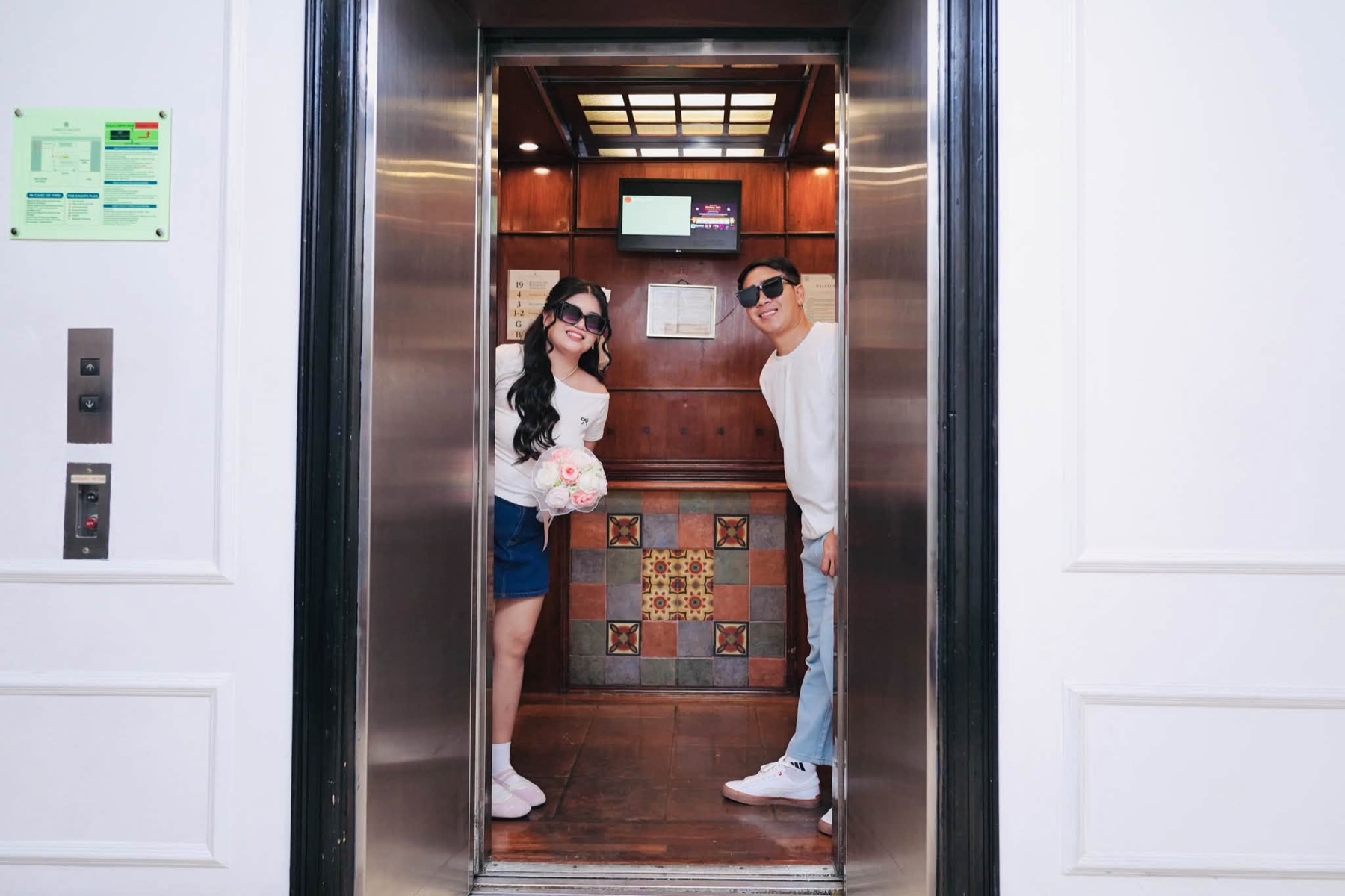 Rachel and Jasper smiling together in an elevator