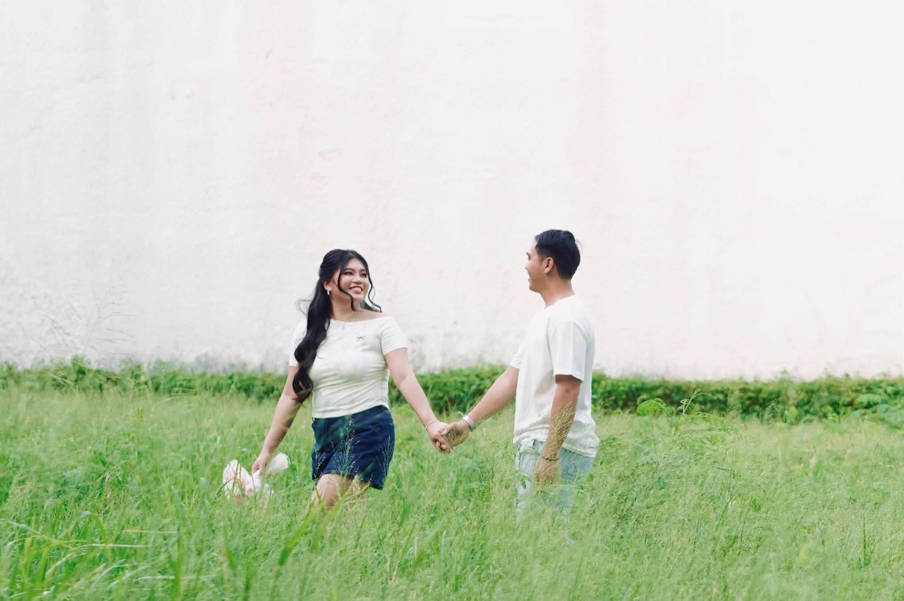 Rachel and Jasper holding hands in a field