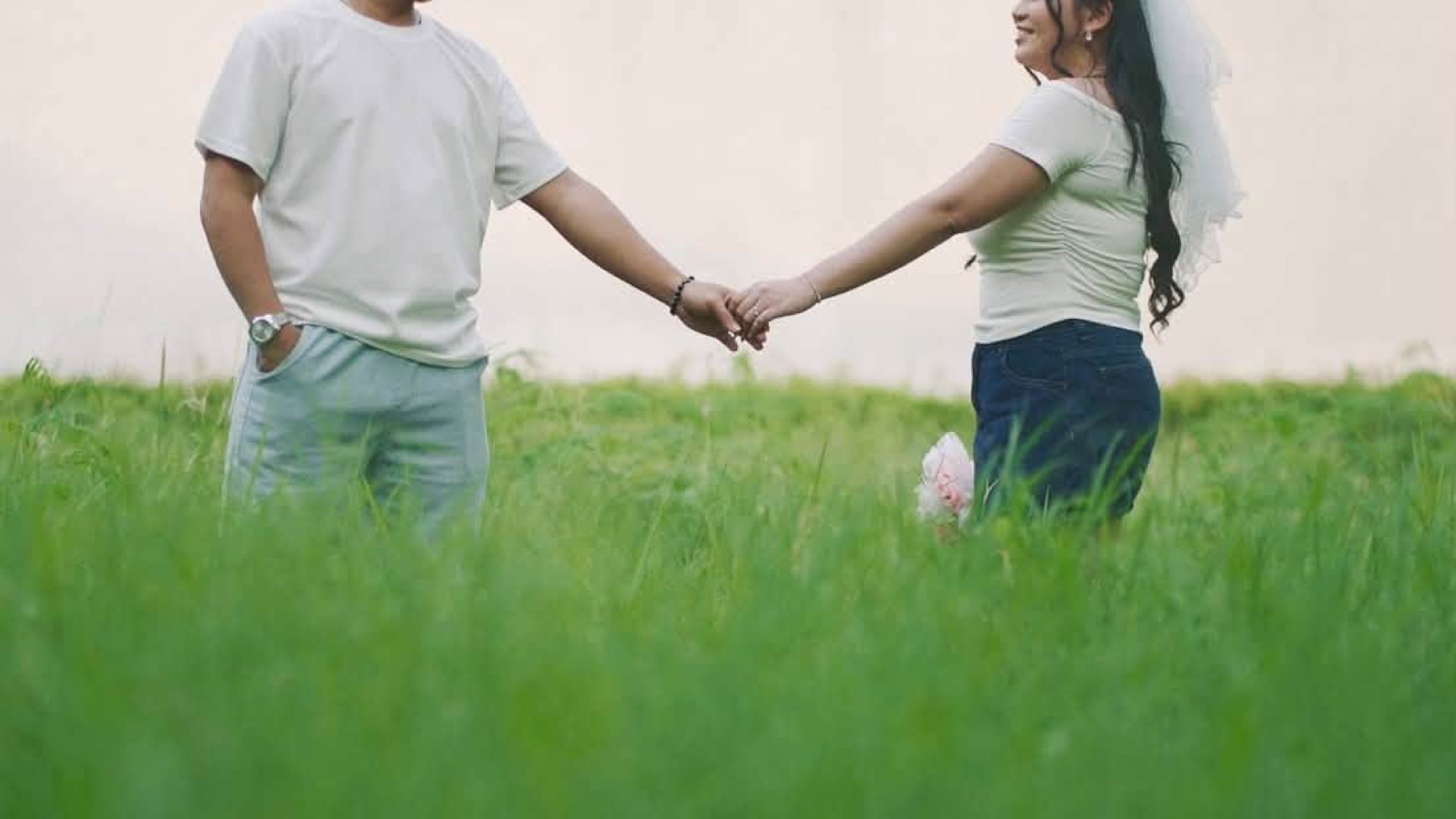 Rachel and Jasper holding hands in a field