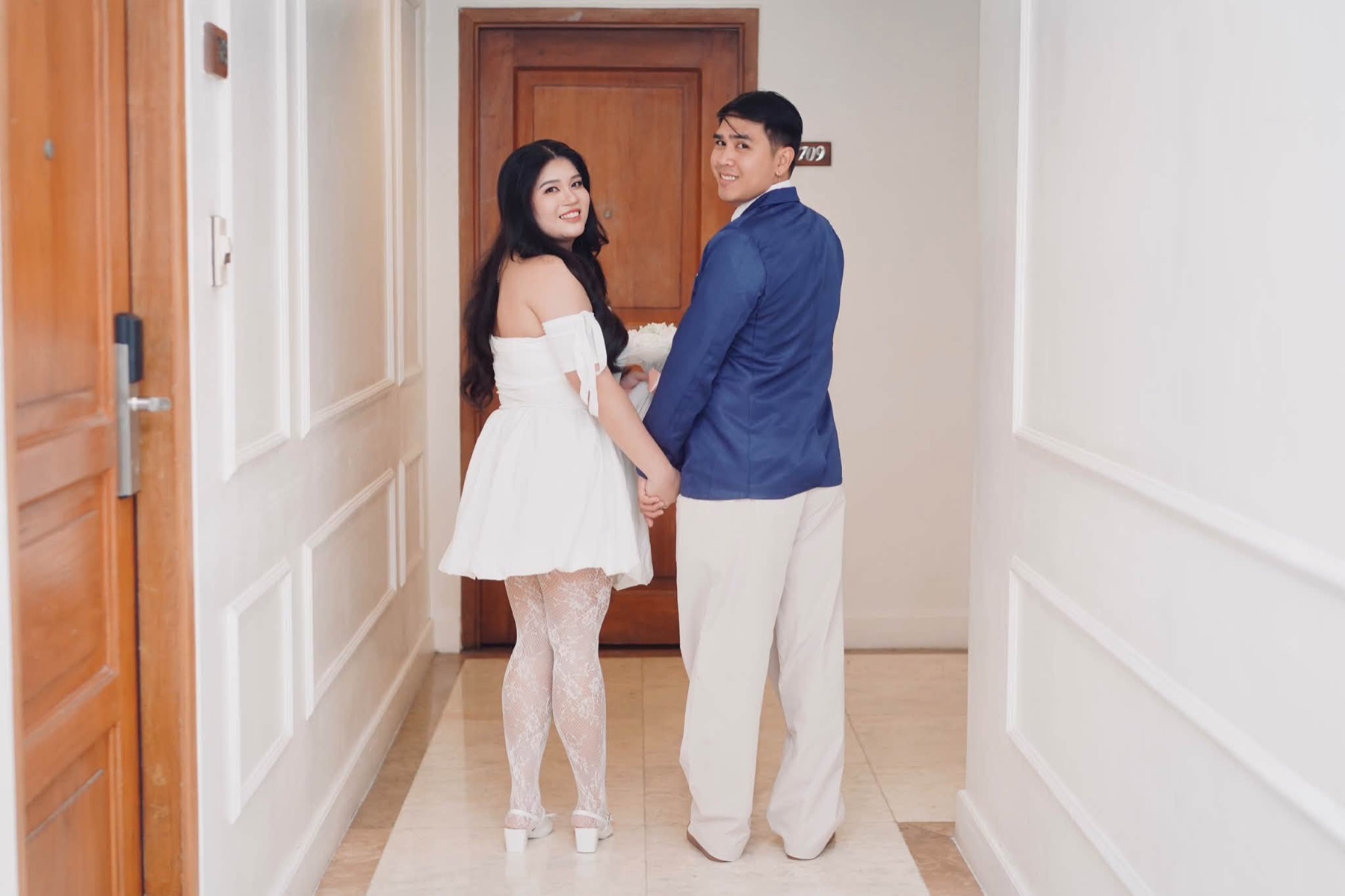 Rachel and Jasper looking back together in a hallway
